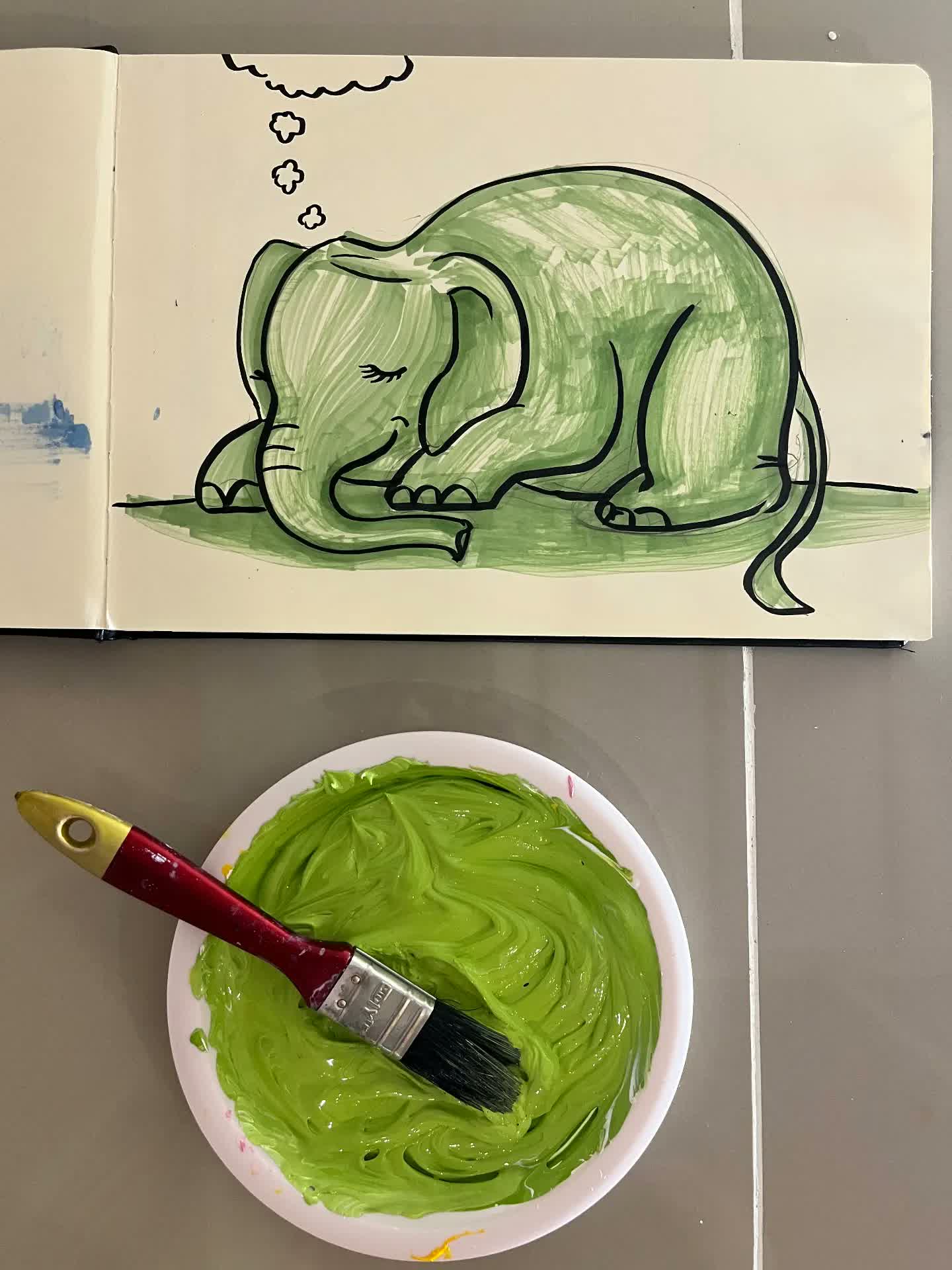 Esbós de l'elefant verd al quadern amb la pintura verda